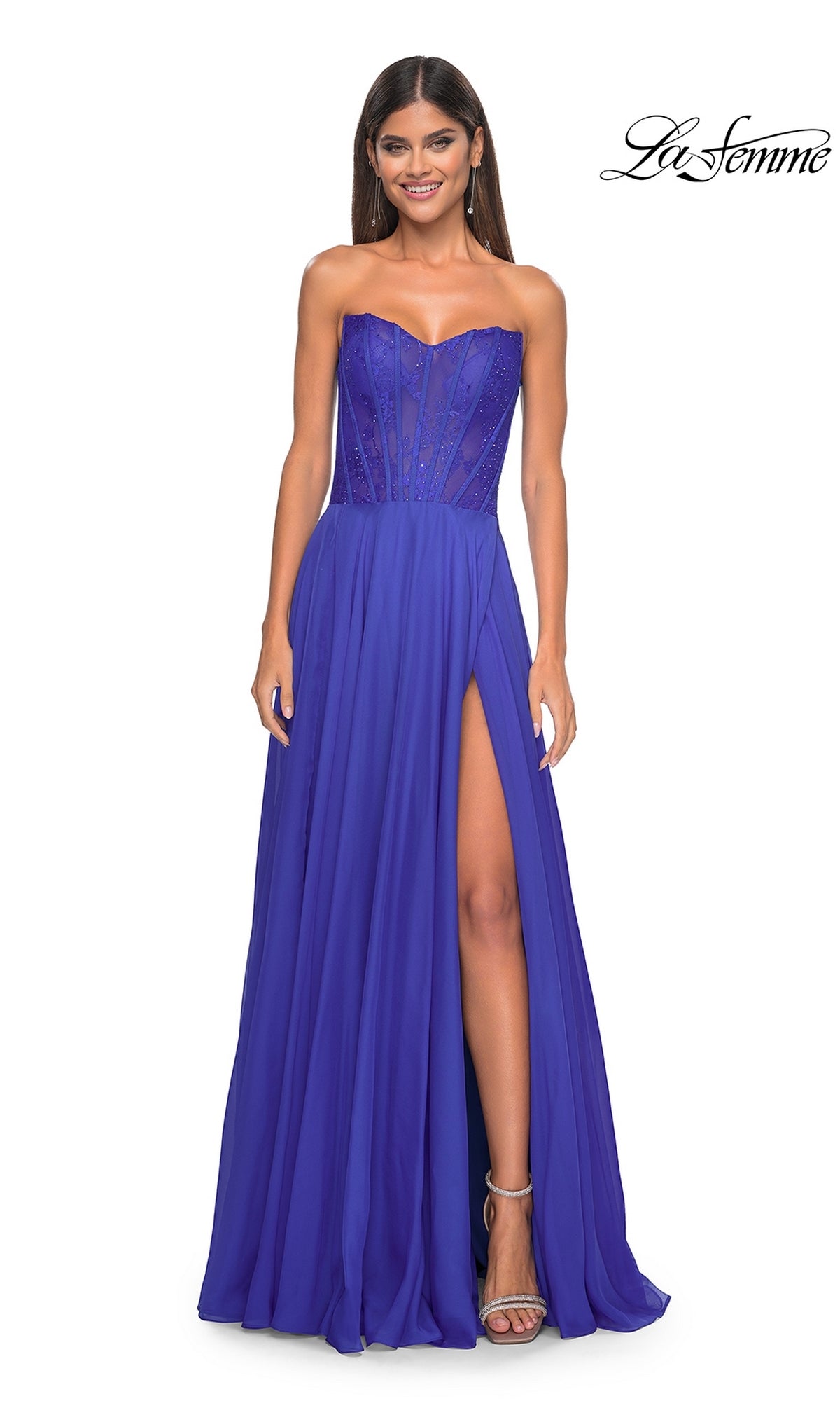 Woman wearing the La Femme Lace-Bodice Long A-Line Prom Dress 32311, featuring a strapless fitted bodice with sheer panels, flowing skirt, and high slit, stands smiling.